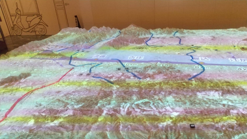 地形を立体的に表す模型に七夕豪雨の洪水地点や川の変遷の様子などを投影