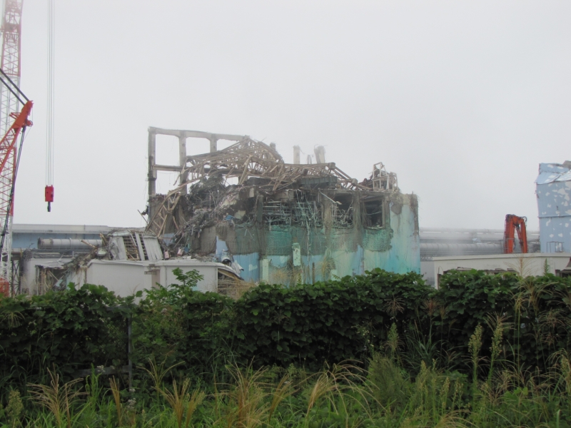 東京電力が発表した写真「３号機原子炉建屋上部（ガレキ撤去作業前）撮影日：平成23年９月15日 」爆発で破壊された3号機原子炉建屋後ろの横に長い建物がタービン建屋。原子炉建屋の壁の青緑色は、放射性物質の飛散防止剤。右には4号機原子炉建屋の壁の一部が見える