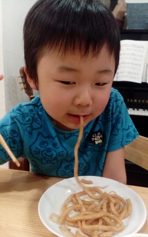 なみえ焼きそばを頬張る息子。太麺なので1本ずつ食べていました。