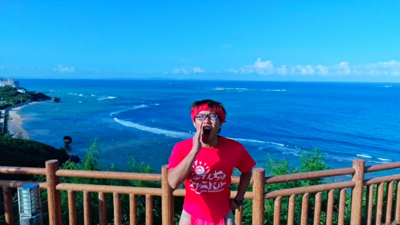 沖縄の美しい海を背景に赤い衣装とアクロバット、マシンガントークに引き込まれる。