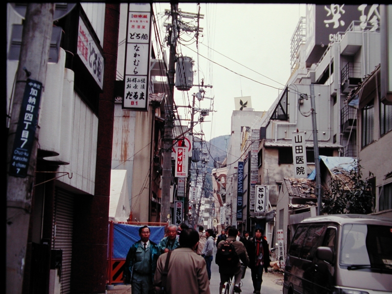 神戸市三宮付近。奥の方でビルが傾いているのに、何もなかったかのように人々が往来する。