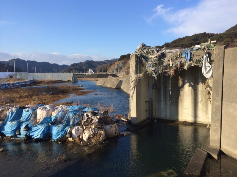 2015年1月1日、岩手県大槌町の港の水門の様子。罹災時のガレキがそのままの姿で残る。「日本は先進国だと思っていたけれど、震災から4年近く経ってもこんな状態なのか」と海外からの参加者は驚くに違いない。