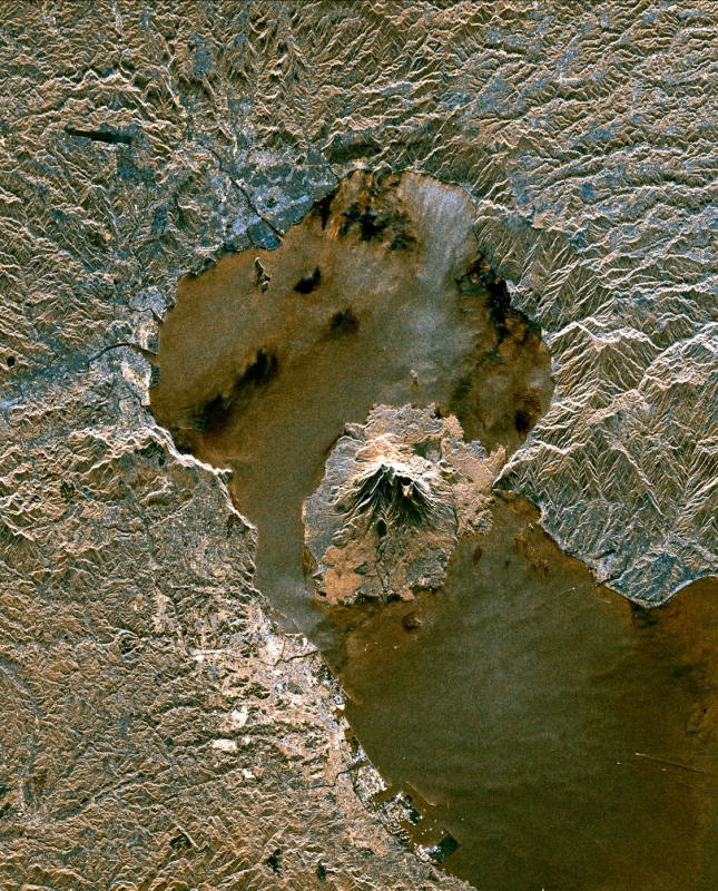 1994年10月にスペースシャトル・エンデバーのC/Xバンド合成開口レーダーによって撮影された姶良カルデラ。鹿児島湾の中央に位置する桜島の東側には、大正大噴火で島と半島をつないだ溶岩流が見て取れる。桜島の北、円形の鹿児島湾最奥部が姶良カルデラ。地形の凹凸が強調された画像により、カルデラ外周に当たる海岸線が切り立っているのが分かる。姶良カルデラ本体のマグマ溜まり中心は桜島の北方にあると考えられている。画像はNASAのパブリックドメイン
