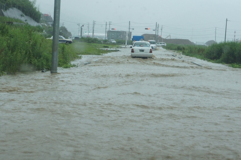 大雨で冠水した国道398号の向うに江島共済会館が見える（2013年7月）
